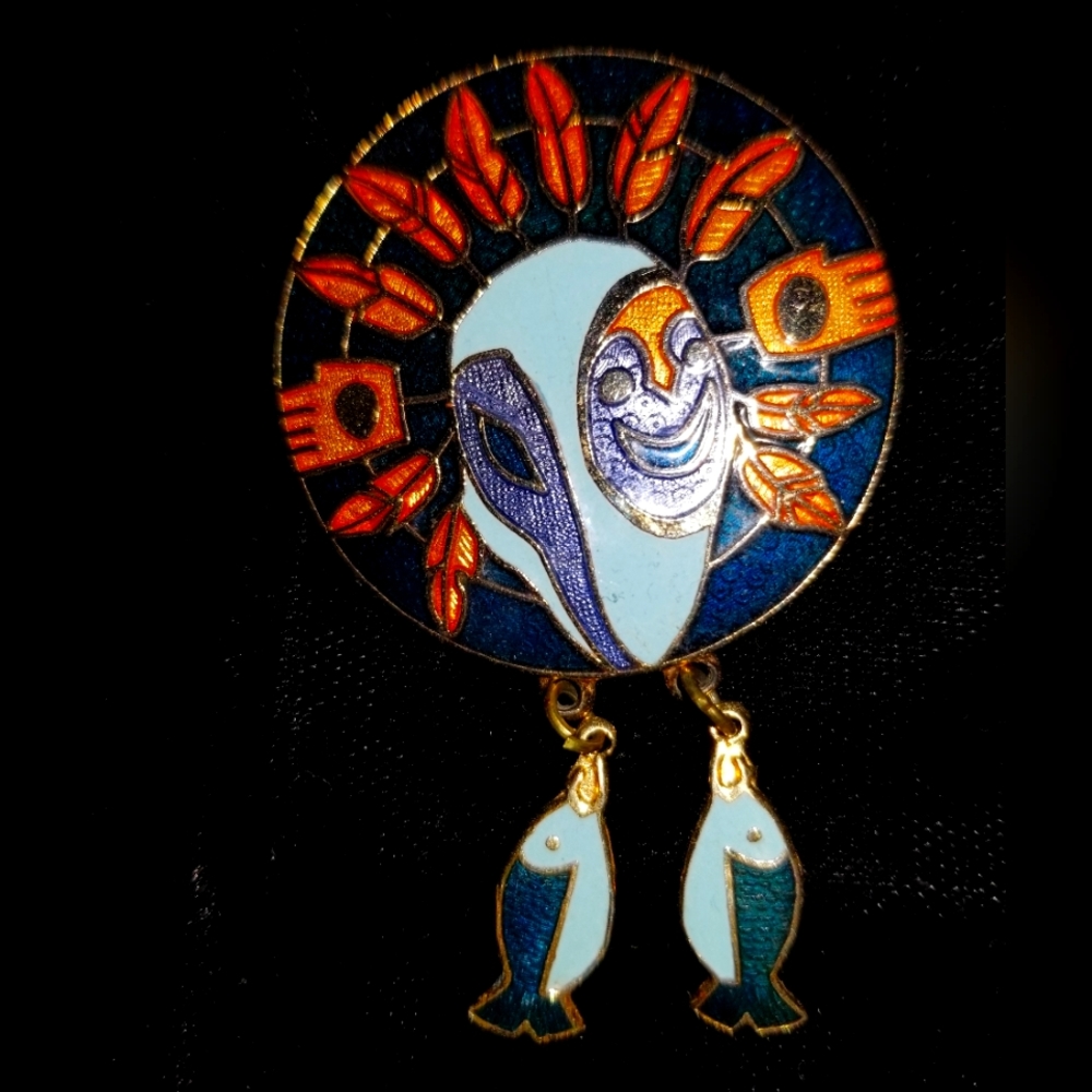 Babara Lavallee pin. Enamel goldtone symbolic mask, feathers & fish charms.